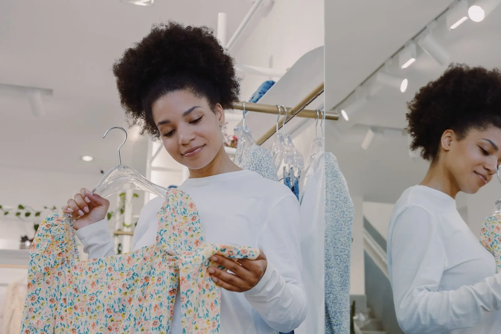 A boutique owner arranging a rail of new stock
