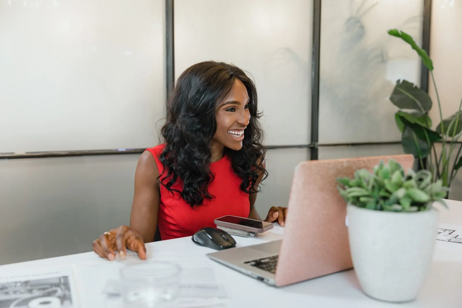 A founder smiling at her laptop in her studio
